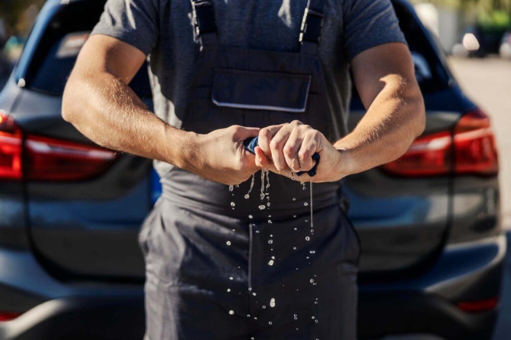 Medewerker wringt een spons uit tijdens het wassen